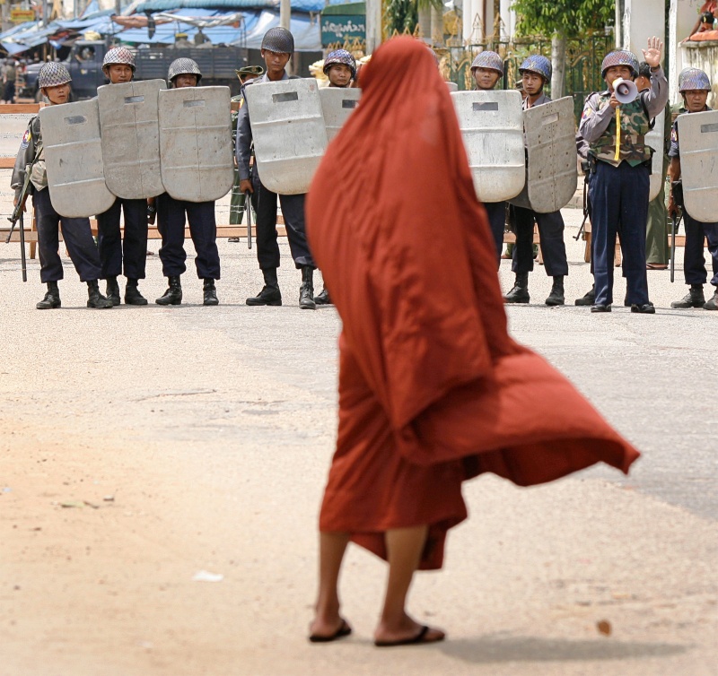 Een domenstrerende monnik wordt tegengehouden door politie en militairen, Rangoon, 2007. Foto: Adrees Latif/Reuters