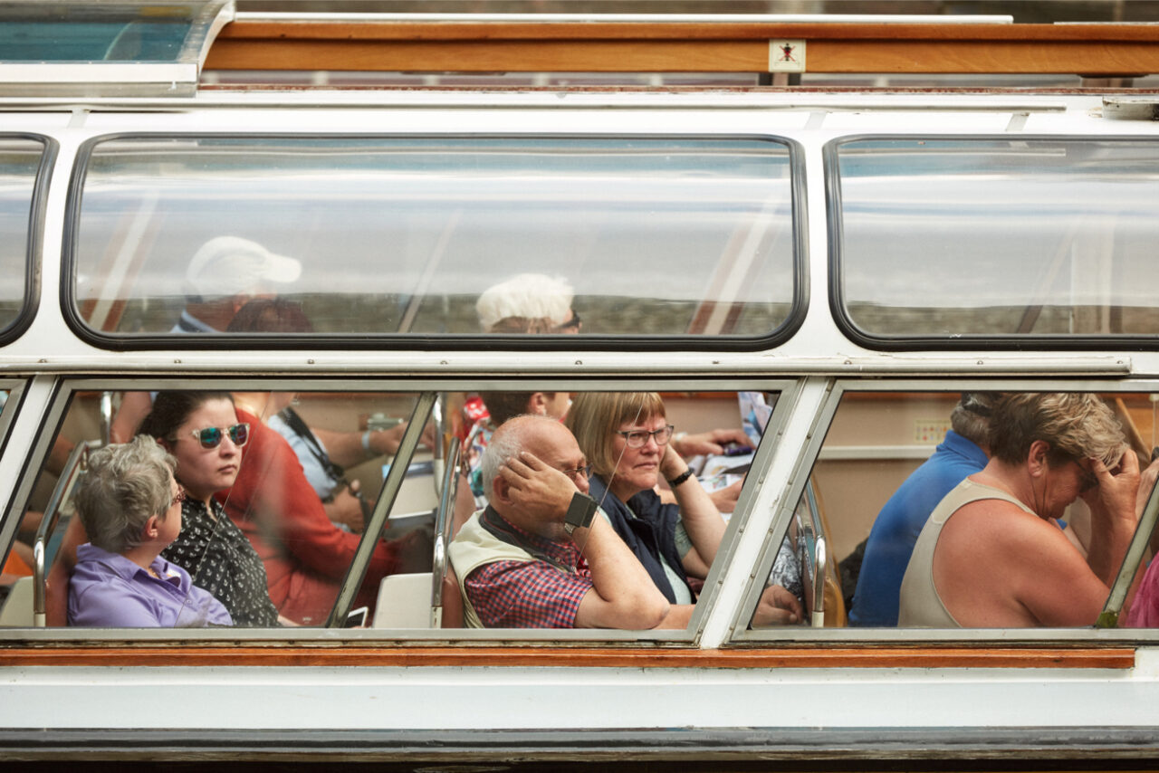 Toeristen in een rondvaartboot, gefotografeerd vanaf de zijkant